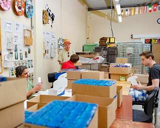 Freiwillige packen Kartons in einem hellen Raum.